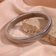 Bracelet jonc flexible en acier inoxydable argenté, maille spirale fine et brillante.