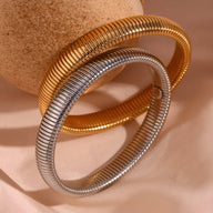 Bracelet jonc flexible à maille en acier inoxydable, finitions or et argent brillante.