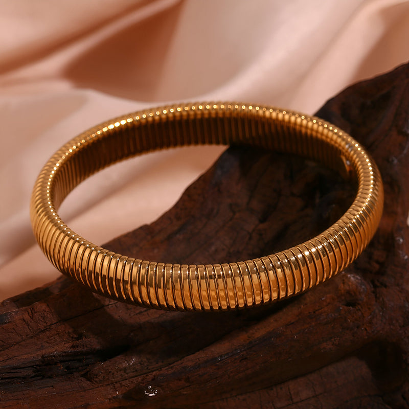 Bracelet jonc flexible en acier inoxydable doré, maille serpent élégante et lisse.