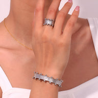 Bracelet jonc en acier inoxydable argenté avec détails sphériques élégants porté au poignet féminin.