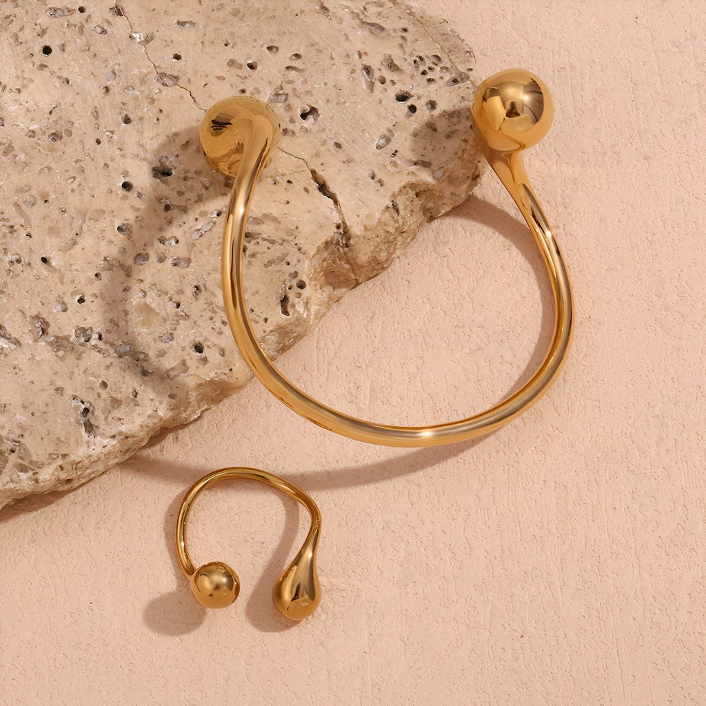 Bracelet jonc en acier inoxydable doré avec extrémités rondes bombées et design épuré.