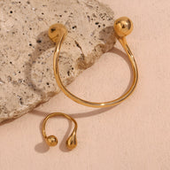 Bracelet jonc en acier inoxydable doré avec extrémités rondes bombées et design épuré.