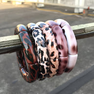 Lot de cinq bracelets joncs en acrylique avec motifs léopard multicolores pour femme.