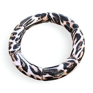 Bracelet jonc femme en acrylique avec motif léopard noir et beige style segments arrondis.