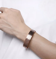 Bracelet jonc magnétique en cuivre bronze avec gravures décoratives porté au poignet homme.