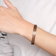 Bracelet jonc magnétique en cuivre bronze avec motifs gravés porté au poignet homme.