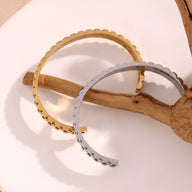 Bracelet jonc en acier inoxydable or à maille gourmette festonnée et bracelet argenté aux bords festonnés.