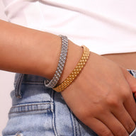 Bracelet jonc maille gourmette en acier inoxydable, modèle Ella, coloris or et argent porté sur poignet féminin.