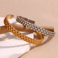 Bracelet jonc maille gourmette en acier inoxydable couleur or doux et argent brillant sur fond beige.