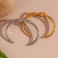 Bracelet jonc en acier inoxydable or et argent avec maillon central unique et design élégant.