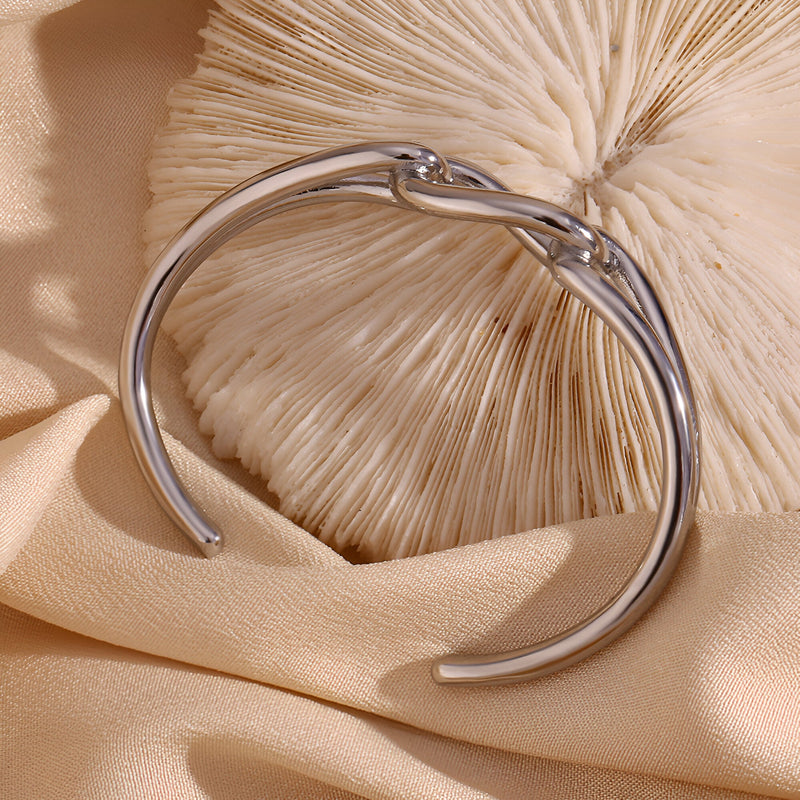 Bracelet jonc argent en acier inoxydable avec maillon central unique et design épuré.