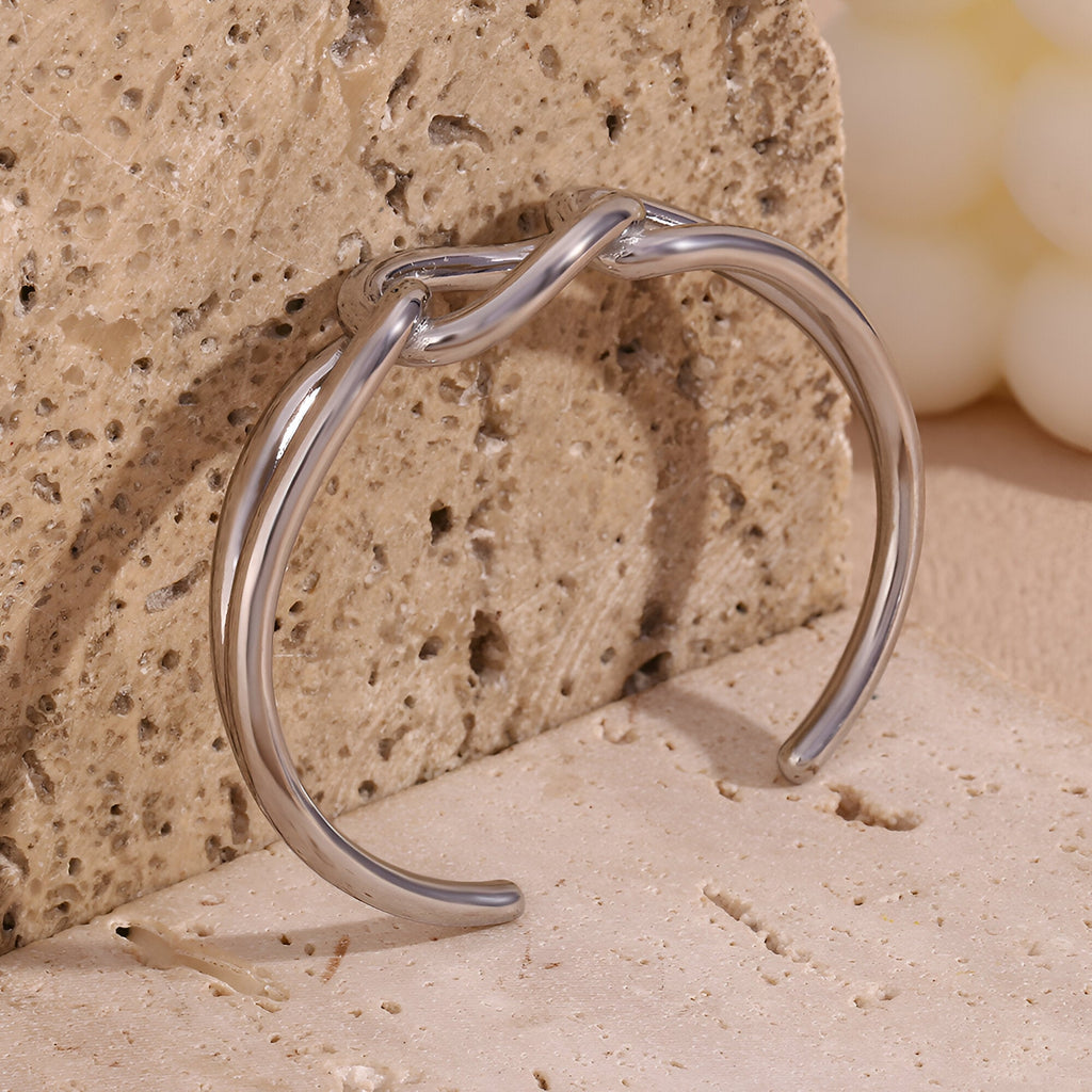 Bracelet jonc argent en acier inoxydable avec maillon central unique et design épuré.