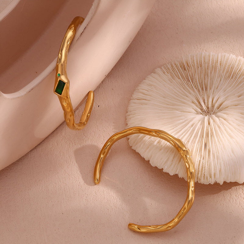 Bracelet jonc doré ondulé avec pierre verte rectangulaire en acier inoxydable.