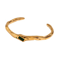 Bracelet jonc ondulé en acier inoxydable doré avec pierre verte rectangulaire intégrée.