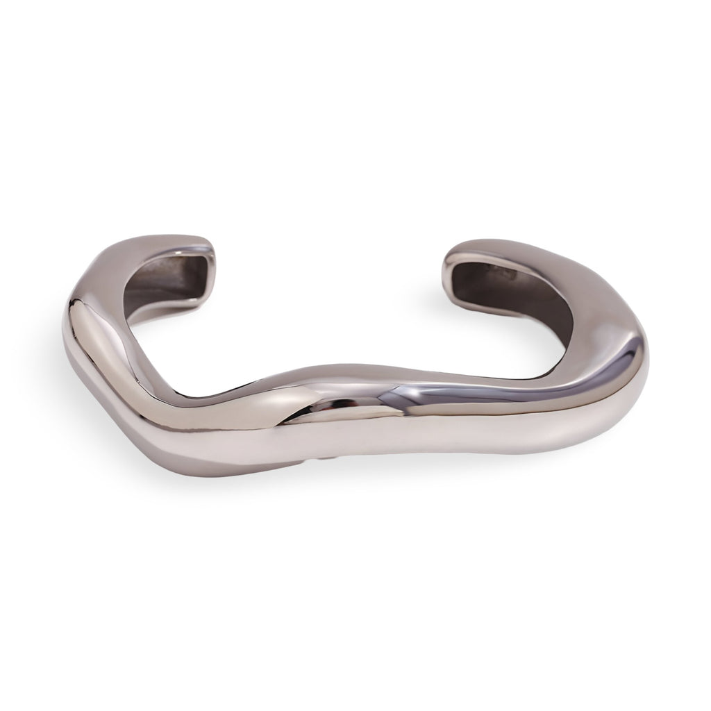 Bracelet jonc ondulé en acier inoxydable argenté à finition brillante et forme organique fluide.