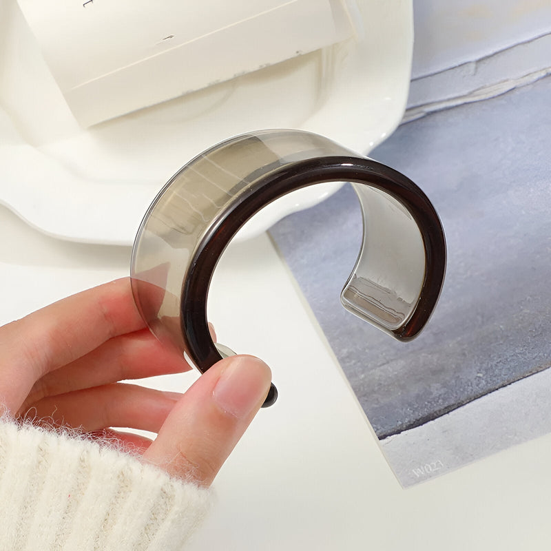 Bracelet jonc ouvert en résine transparente avec bord marron foncé, style moderne pour femme.