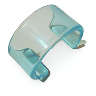 Bracelet jonc ouvert en résine bleu transparent au design épuré et moderne.
