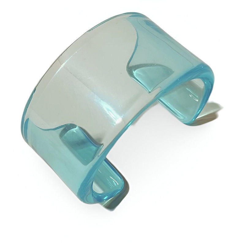Bracelet jonc ouvert en résine bleu transparent au design épuré et moderne.
