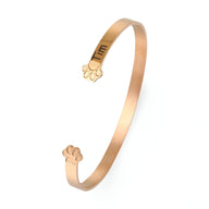 Bracelet jonc en or rosé avec motifs de patte d'animal gravés aux extrémités.