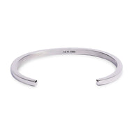 Bracelet jonc en acier inoxydable argenté avec gravure fine intérieure, style minimaliste et unisexe.
