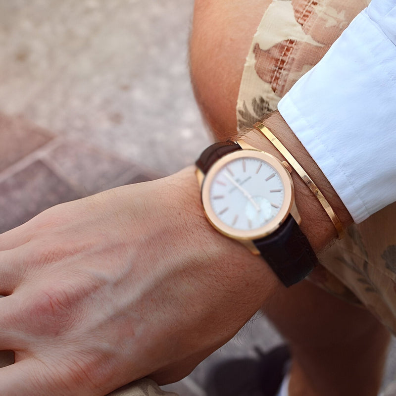 Bracelet jonc fin en acier inoxydable doré, design minimaliste et élégant, porté au poignet.