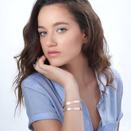 Bracelet jonc en argent sterling avec motifs cœur gravés porté sur poignet féminin, style minimaliste élégante.