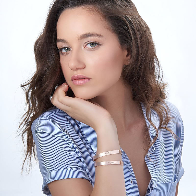 Bracelet jonc en argent sterling avec motifs cœur gravés porté sur poignet féminin, style minimaliste élégante.