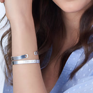 Bracelet jonc argent sterling à motifs cœur et gravure "I DID IT" porté au poignet féminin.