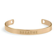 Bracelet jonc en or rosé avec gravure BREATHE et petits motifs cœur découpés aux extrémités.