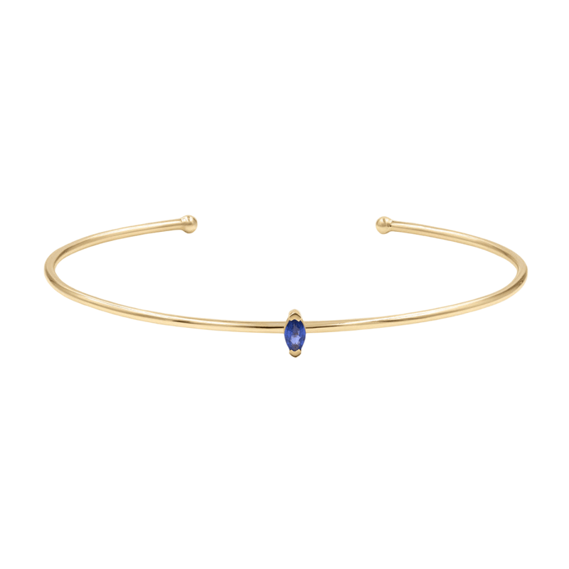 Bracelet jonc fin en acier inoxydable doré avec petite pierre bleue marquise centrale.