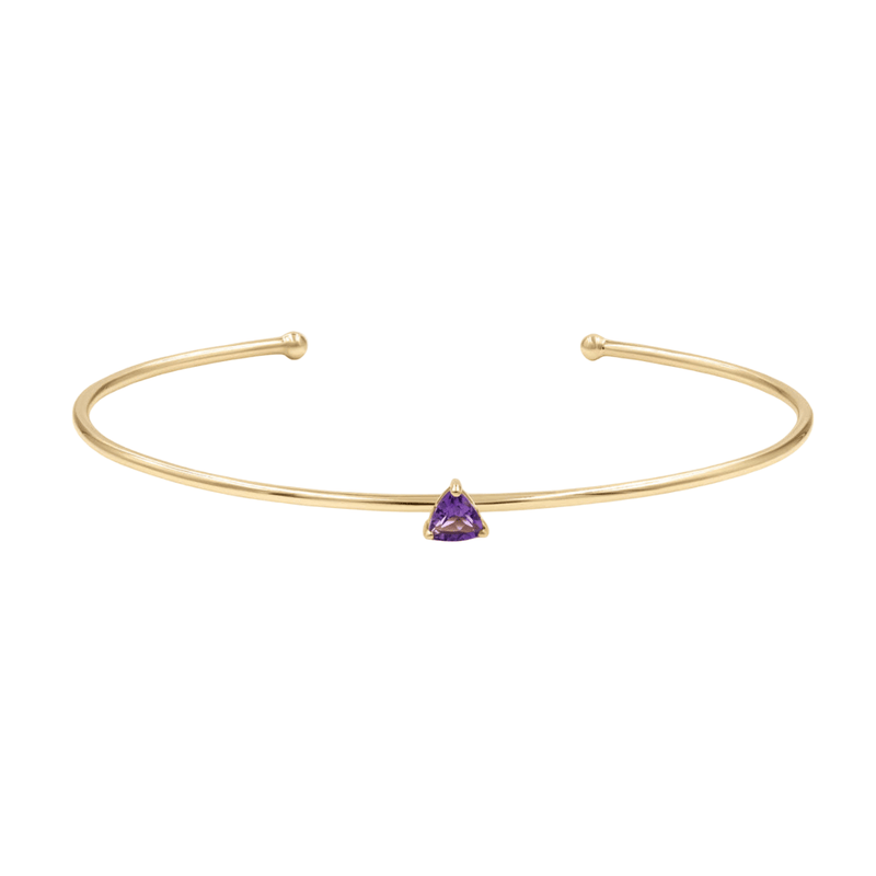 Bracelet jonc fin en acier inoxydable doré avec petite pierre triangulaire violette au centre.