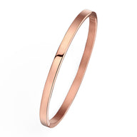 Bracelet jonc fin en titane plaqué or rose 18 carats, finition lisse et brillante.