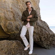 Bracelet jonc en titane noir style crochet d'ancrage porté au poignet d'un homme près de rochers en bord de mer.