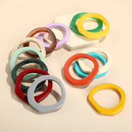 Bracelets jonc irréguliers en résine aux couleurs vives et pastel, design moderne pour femme.