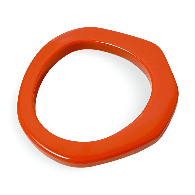 Bracelet jonc irrégulier en résine orange brillant pour femme.