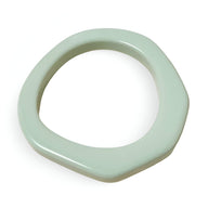 Bracelet jonc irrégulier en résine couleur menthe avec finition lisse et forme organique.