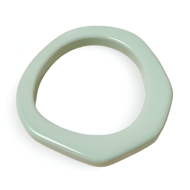 Bracelet jonc irrégulier en résine couleur menthe avec finition lisse et forme organique.