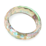 Bracelet jonc en résine translucide aux reflets irisés et facettes géométriques élégantes.