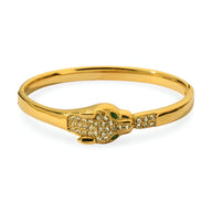 Bracelet jonc doré avec tête de léopard ornée de cristaux et yeux verts, pour femme.