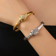 Bracelet jonc or avec tête de léopard aux yeux verts et bracelet jonc argent avec tête de léopard aux yeux verts.
