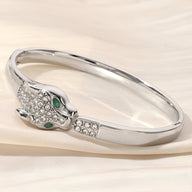 Bracelet jonc argent avec tête de léopard ornée de cristaux et yeux verts éclatants.