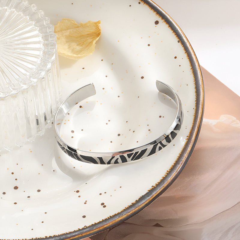 Bracelet jonc en titane argenté avec motif tigré noir, finition lisse et moderne.