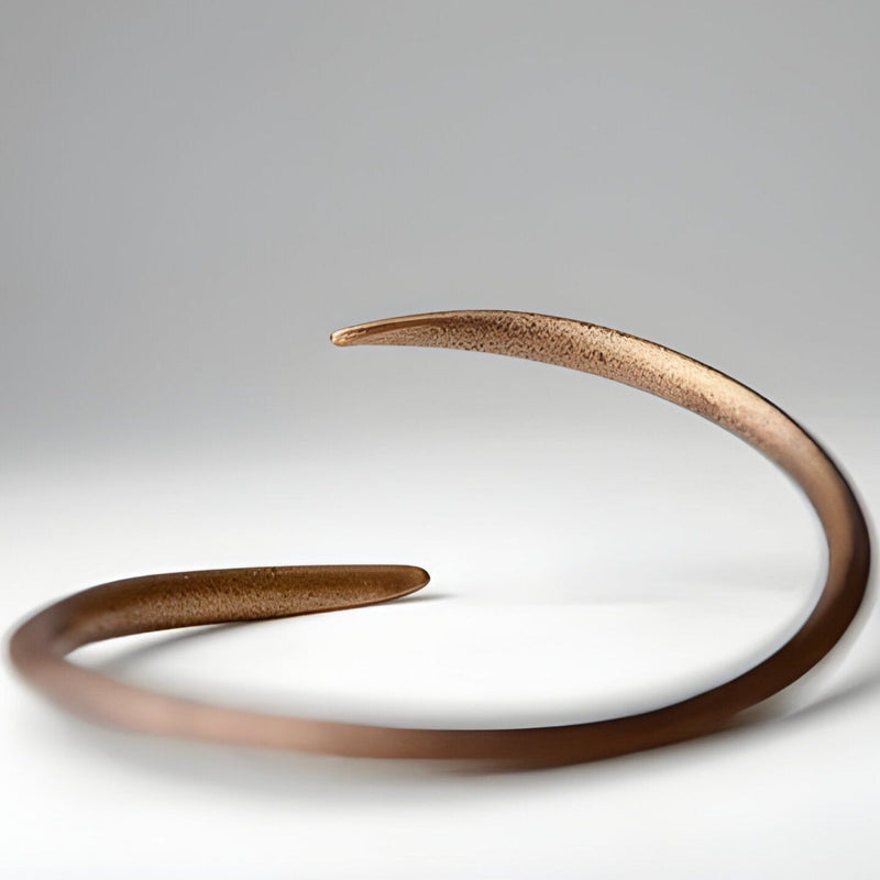 Bracelet jonc torsadé en cuivre vintage, finition mate, extrémités effilées, style minimaliste.