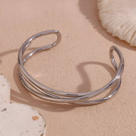 Bracelet jonc en acier inoxydable argenté à trois torsades fines et ouvertes.