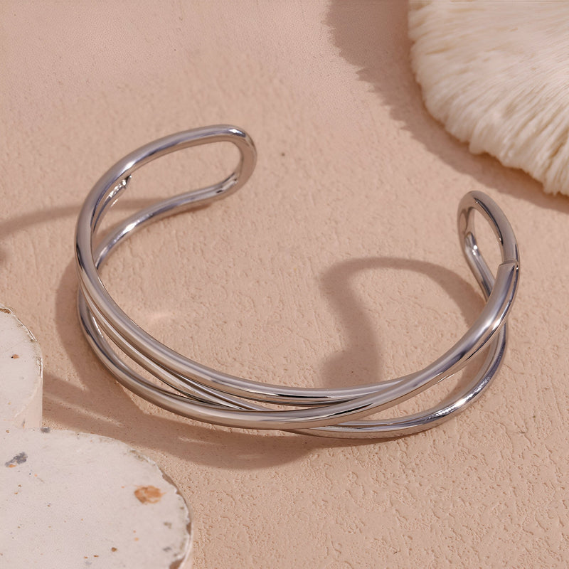 Bracelet jonc en acier inoxydable argenté à trois torsades fines et ouvertes.