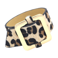 Bracelet large en cuir imprimé léopard beige et marron avec boucle carrée dorée.
