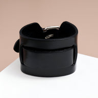 Bracelet large en cuir noir pour homme avec boucle ardillon argentée et design épais.