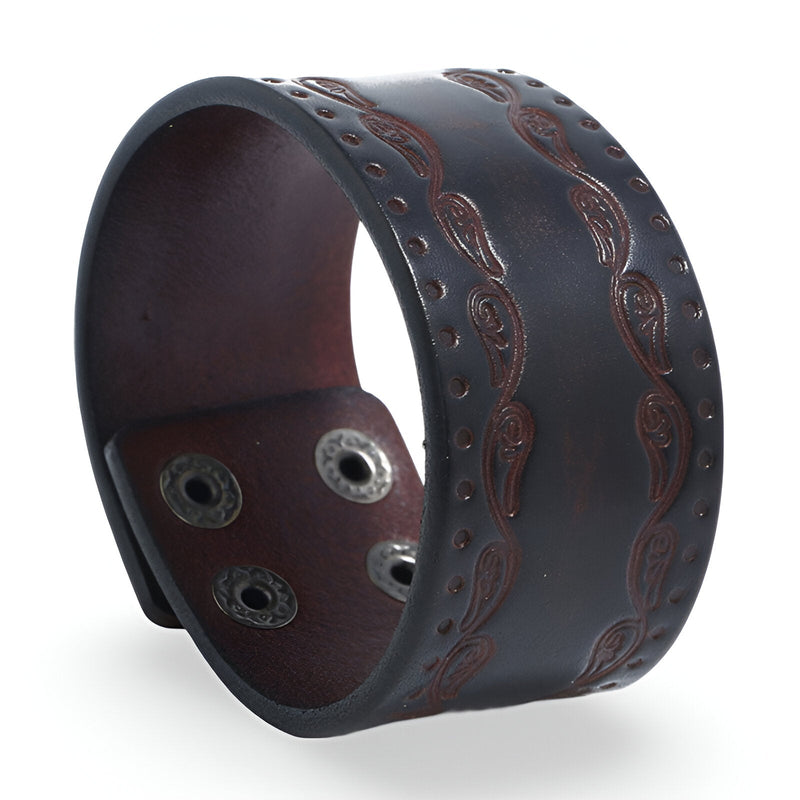 Bracelet large en cuir café avec gravures western et trois boutons-pression métalliques.