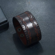 Bracelet large en cuir café avec motifs western embossés et fermeture à boutons pression.
