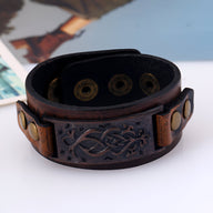 Bracelet large en cuir marron foncé pour homme avec motif floral embossé et boutons pression métalliques dorés.